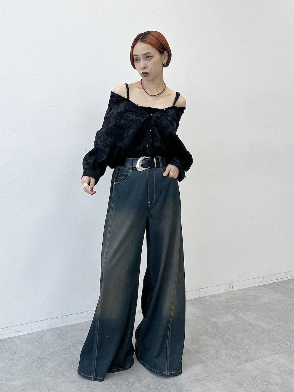 グリーン系のデニムパンツ、ブラック系のスニーカー、ブラック系のシャツ/ブラウスを着用したレディースの夏コーディネートの3枚目の写真