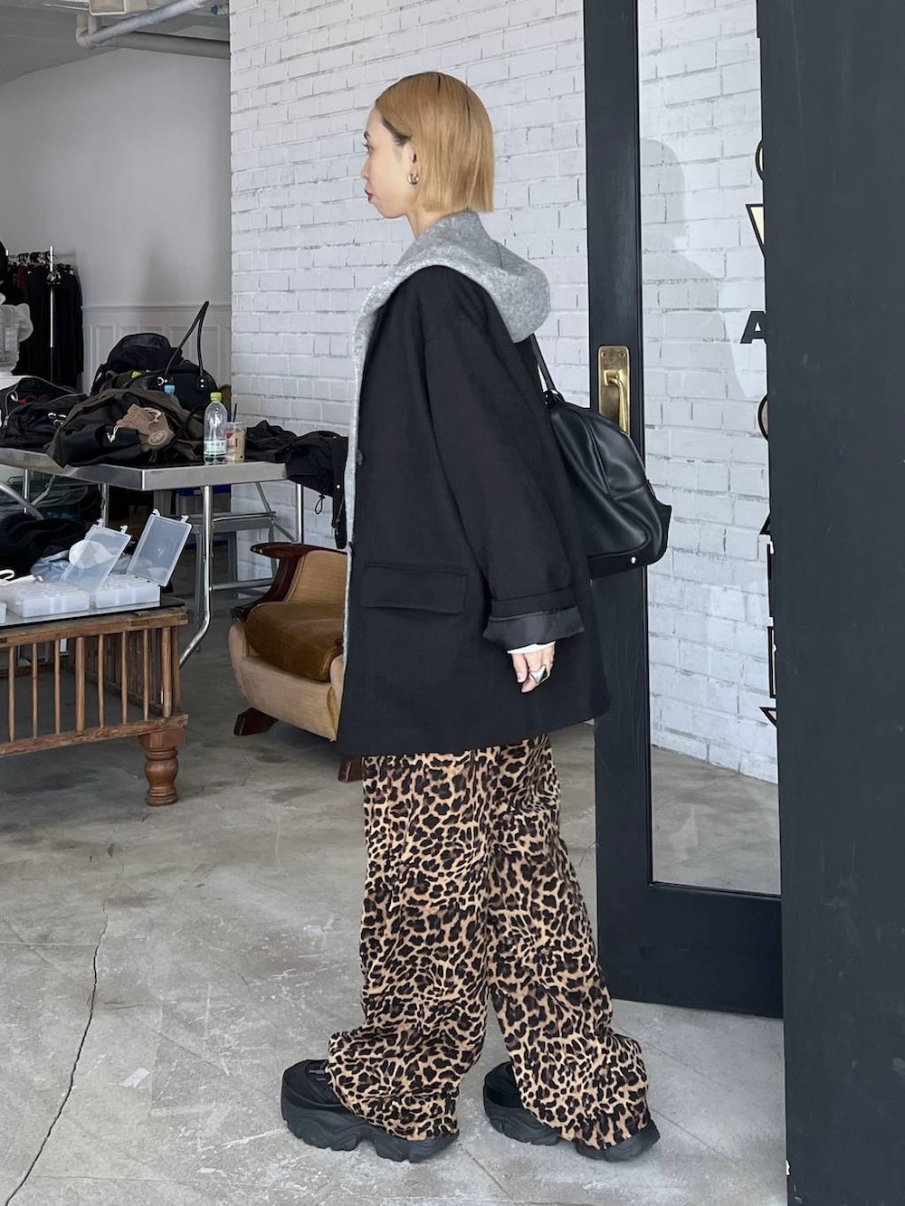 ブラック系のショルダーバッグ、ブラック系のテーラードジャケット、グレー系のマフラーを着用したレディースの秋コーディネートの3枚目の写真