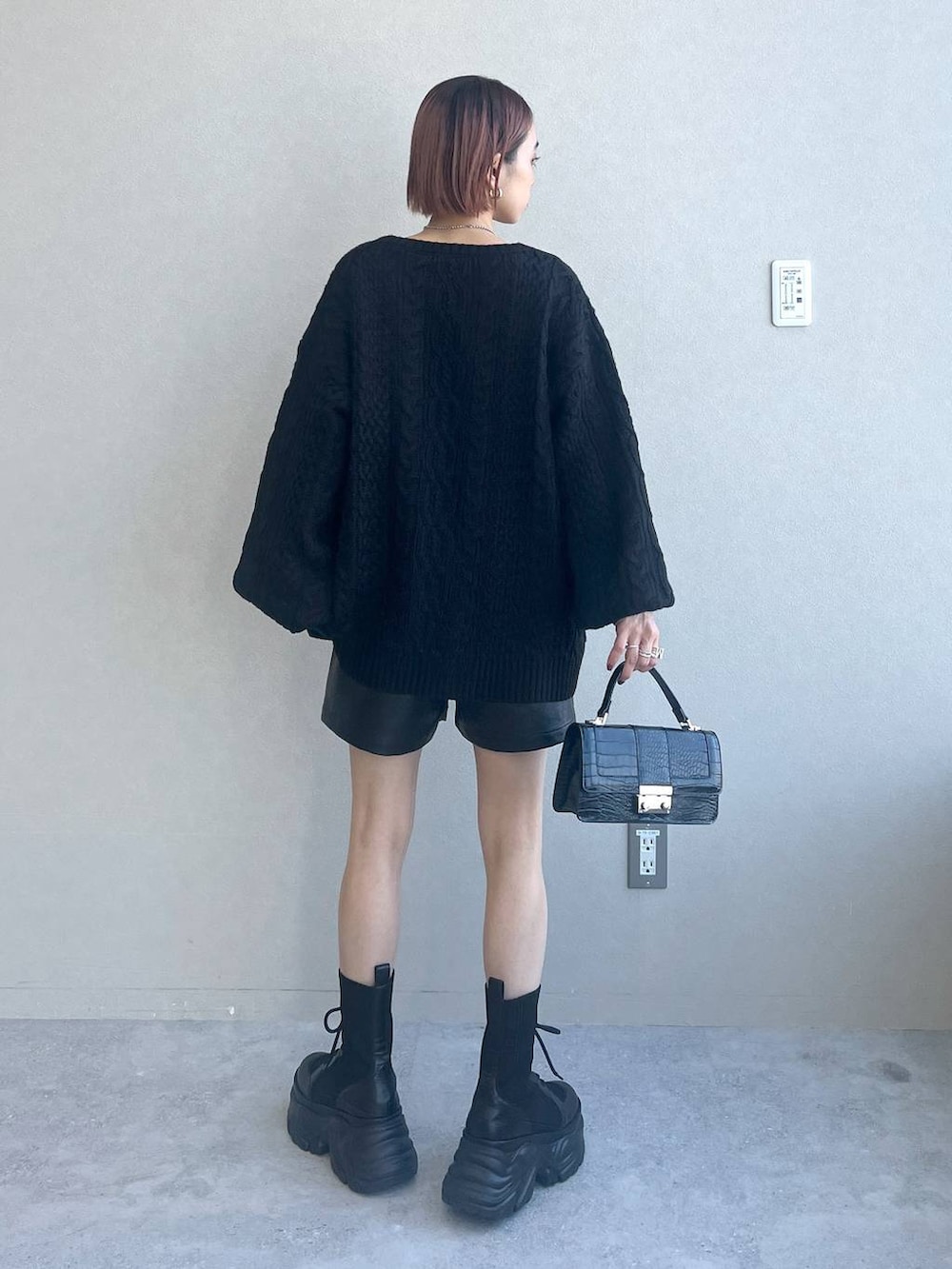 ブラック系のブーツ、ブラック系のハンドバッグ、ブラック系のニット/セーターを着用したレディースの秋コーディネートの4枚目の写真