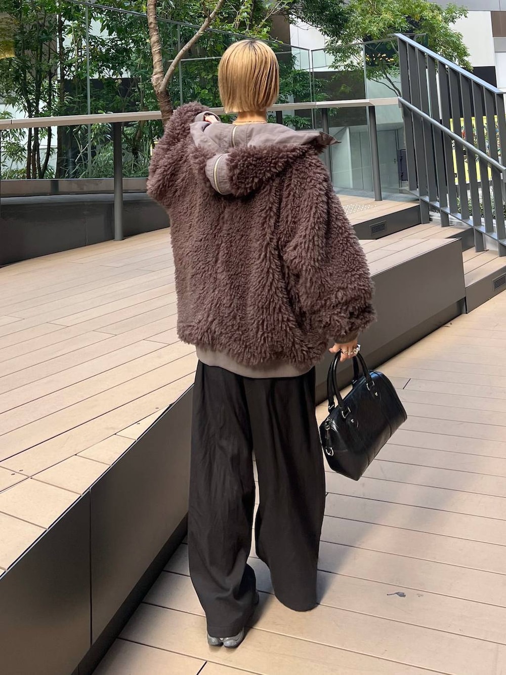 ブラウン系のブルゾン、ブラック系のニット/セーターを着用したレディースの秋コーディネートの4枚目の写真