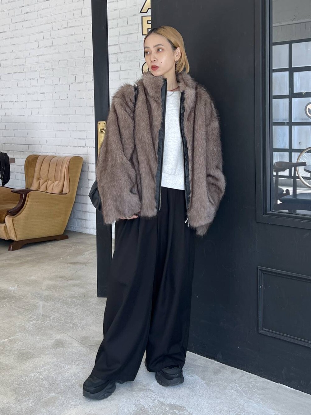 ブラック系のショルダーバッグ、ブラウン系のブルゾンを着用したレディースの秋コーディネートの5枚目の写真