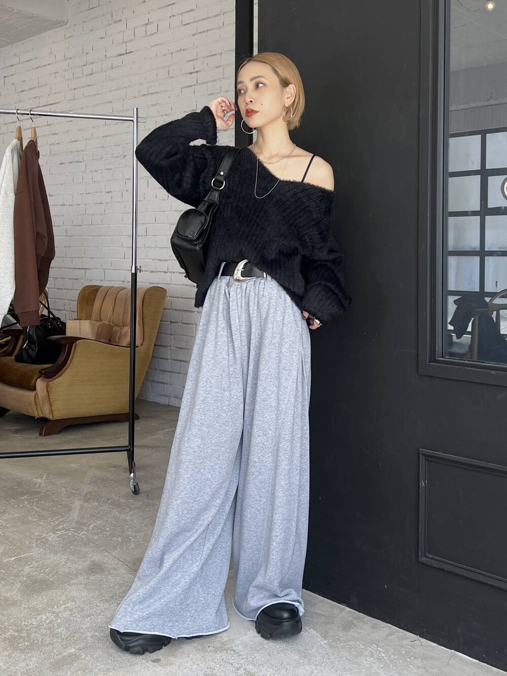 ブラック系のスニーカー、グレー系のスウェットパンツ、ブラック系のニット/セーターを着用したレディースの秋コーディネートの2枚目の写真