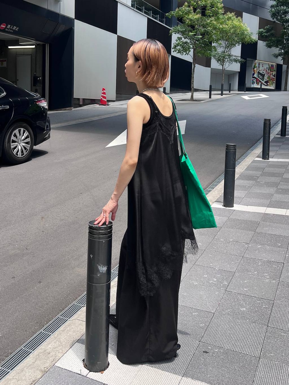 ブラック系のチュニック、ブラック系のスラックス、ブラック系のタンクトップを着用したレディースの夏コーディネートの6枚目の写真