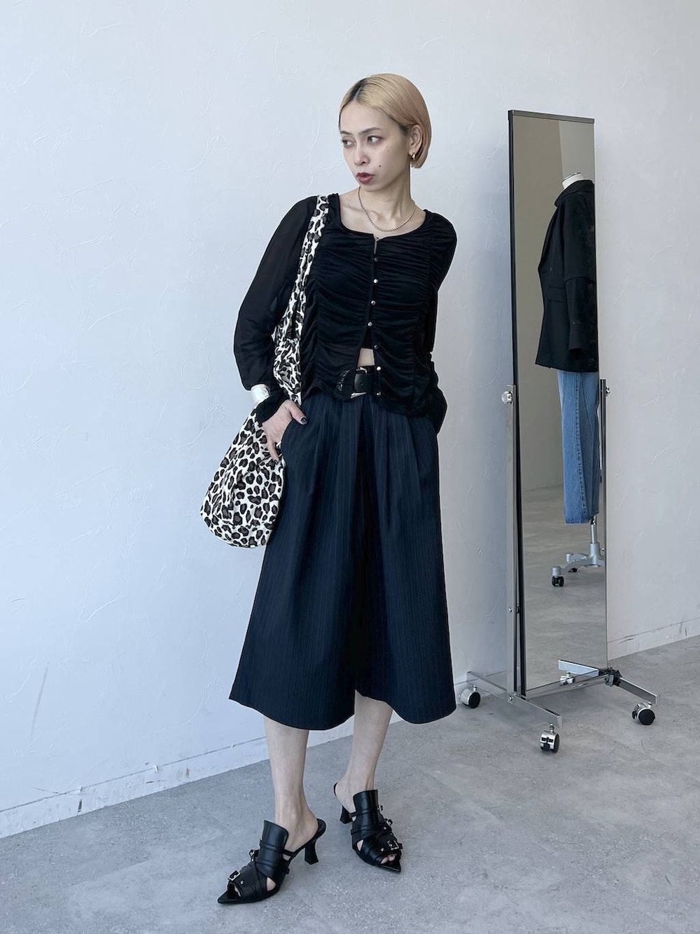 ブラック系のTシャツ/カットソー、ブルー系のスラックス、ブラック系のサンダルを着用したレディースの春コーディネートの2枚目の写真