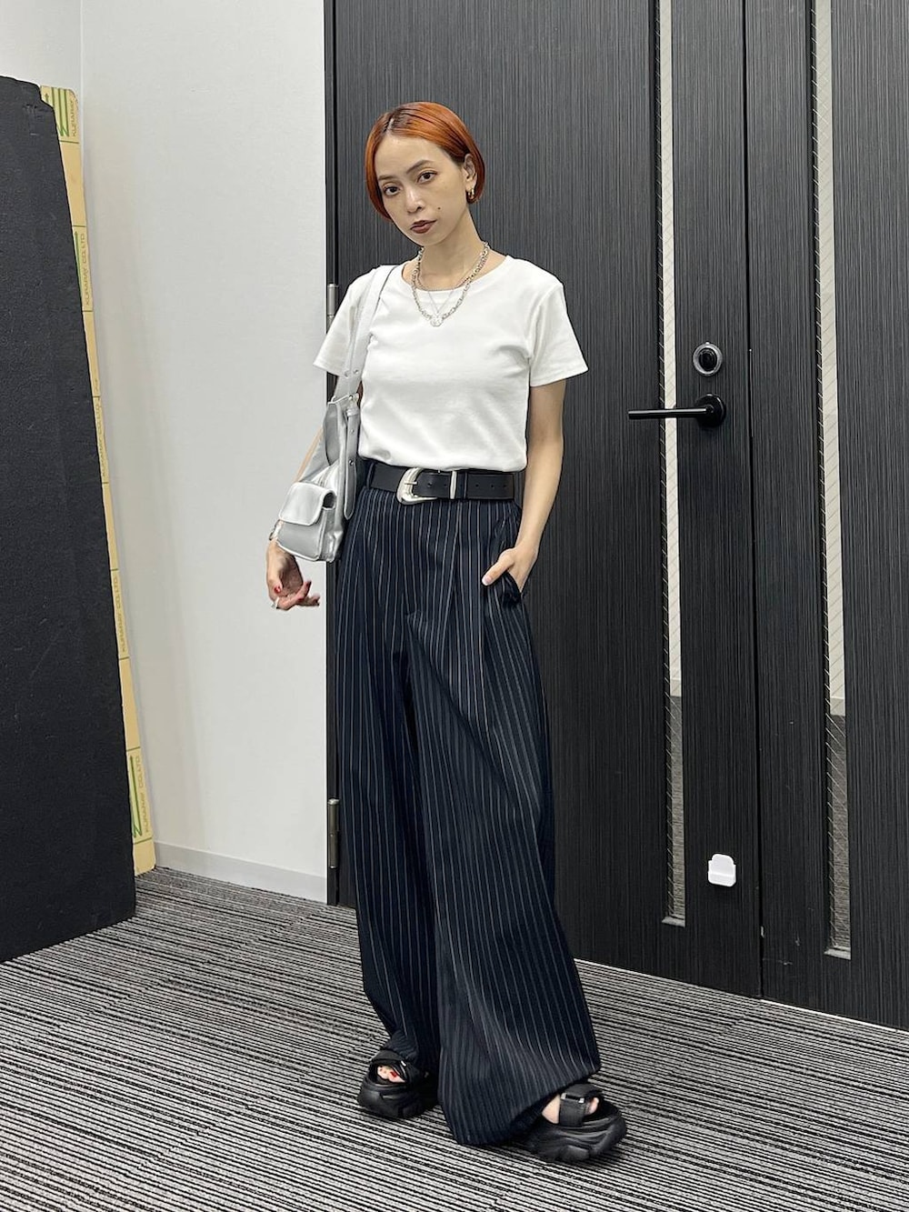 ブラック系のサンダル、シルバー系のハンドバッグ、ホワイト系のTシャツ/カットソーを着用したレディースの夏コーディネートの2枚目の写真