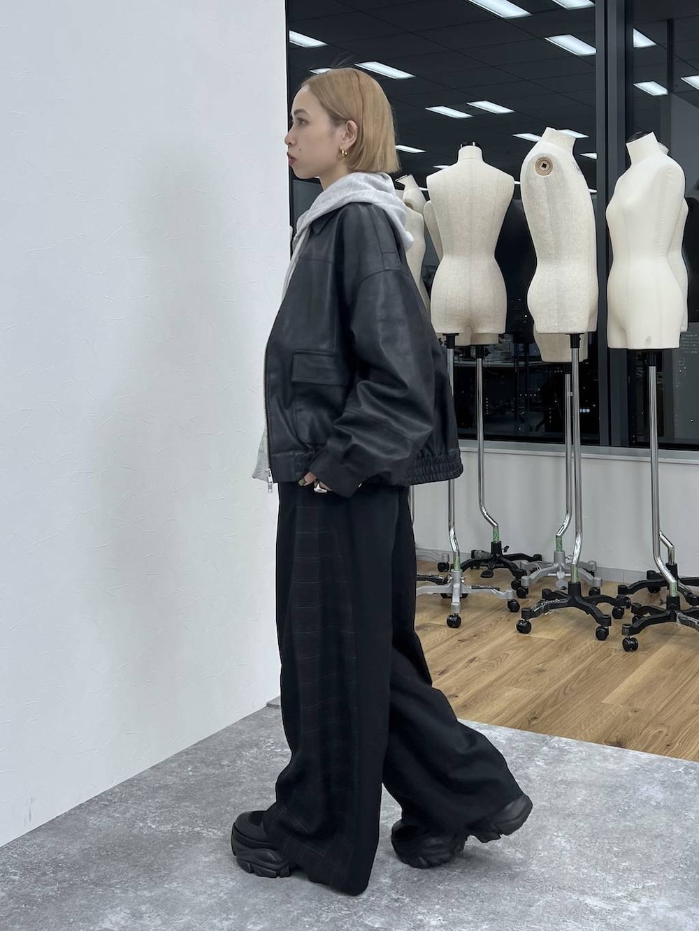 ブラック系のブーツ、ブラック系のスラックス、ブラック系のブルゾンを着用したレディースの秋コーディネートの6枚目の写真