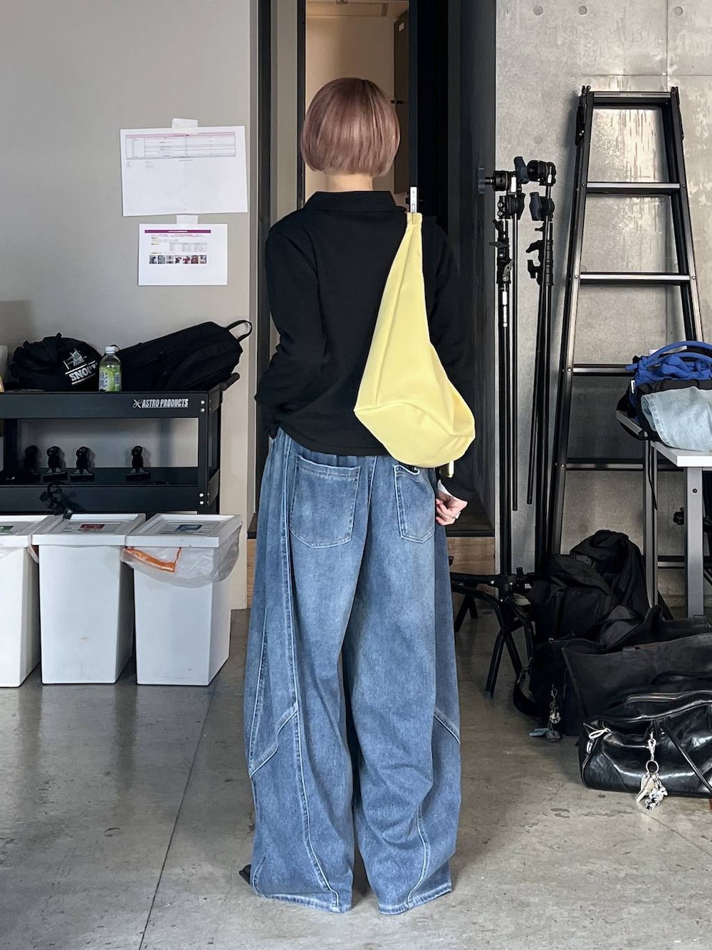 ブラック系のサンダル、イエロー系のトートバッグ、ブルー系のデニムパンツを着用したレディースの冬コーディネートの2枚目の写真