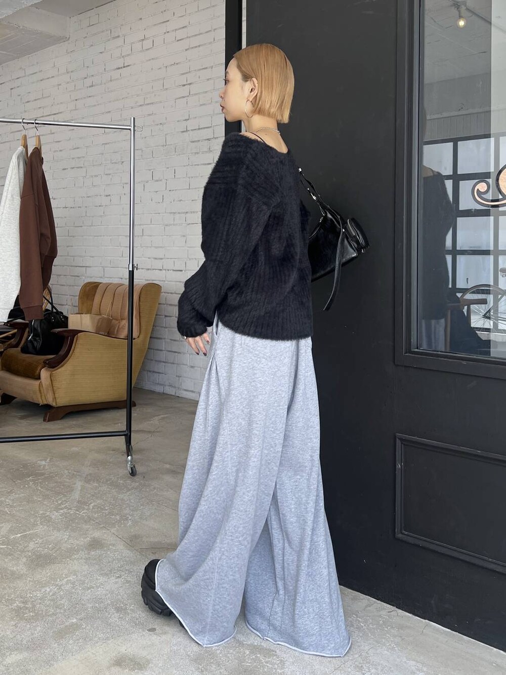 ブラック系のスニーカー、グレー系のスウェットパンツ、ブラック系のニット/セーターを着用したレディースの秋コーディネートの3枚目の写真