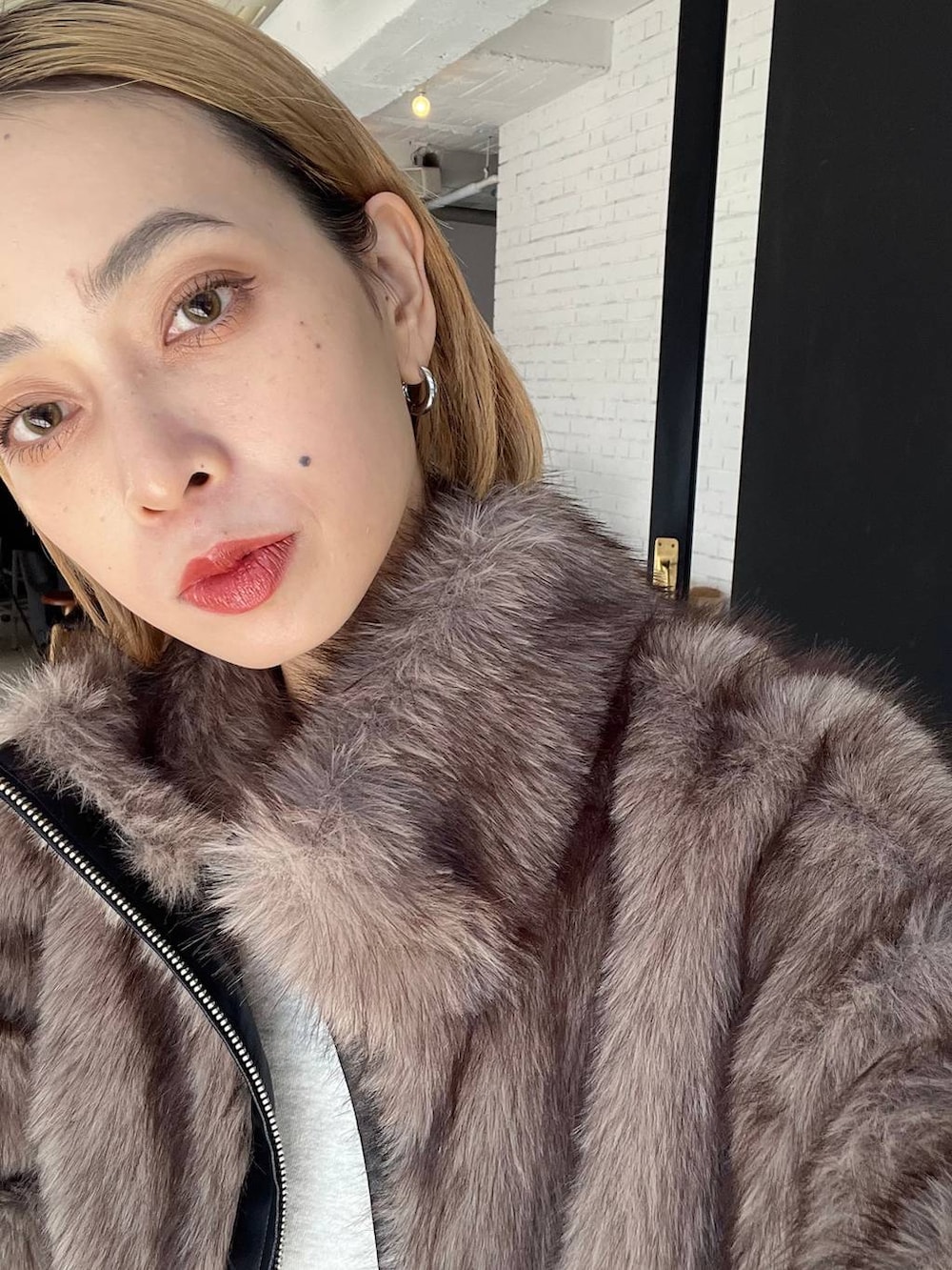 ブラック系のショルダーバッグ、ブラウン系のブルゾンを着用したレディースの秋コーディネートの7枚目の写真