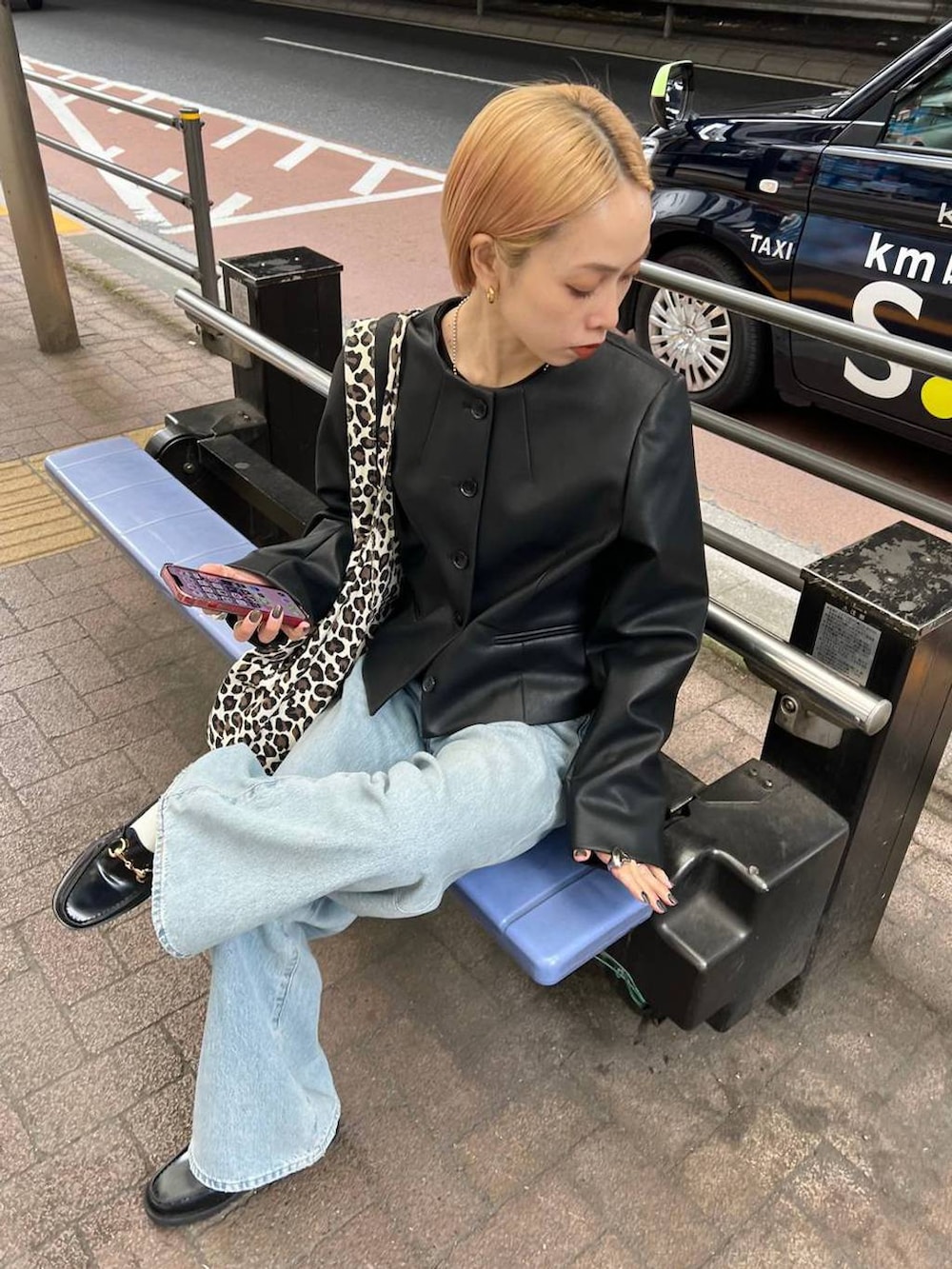 ブラック系のノーカラージャケットを着用したレディースの春コーディネートの3枚目の写真