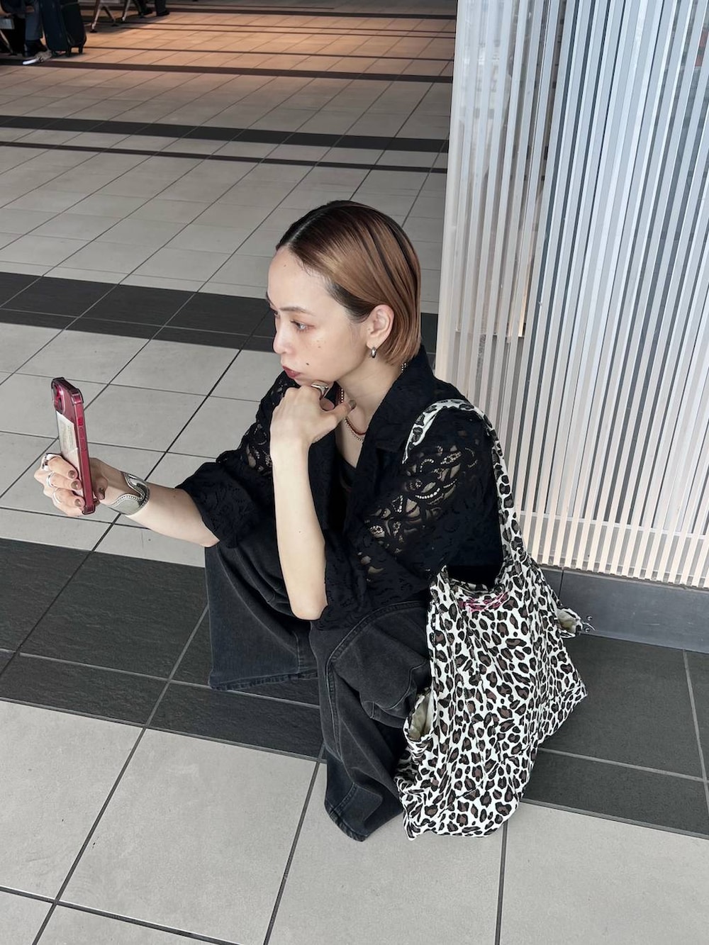 ブラック系のデニムパンツ、ブラック系のテーラードジャケット、ブラウン系のタンクトップを着用したレディースの夏コーディネートの9枚目の写真