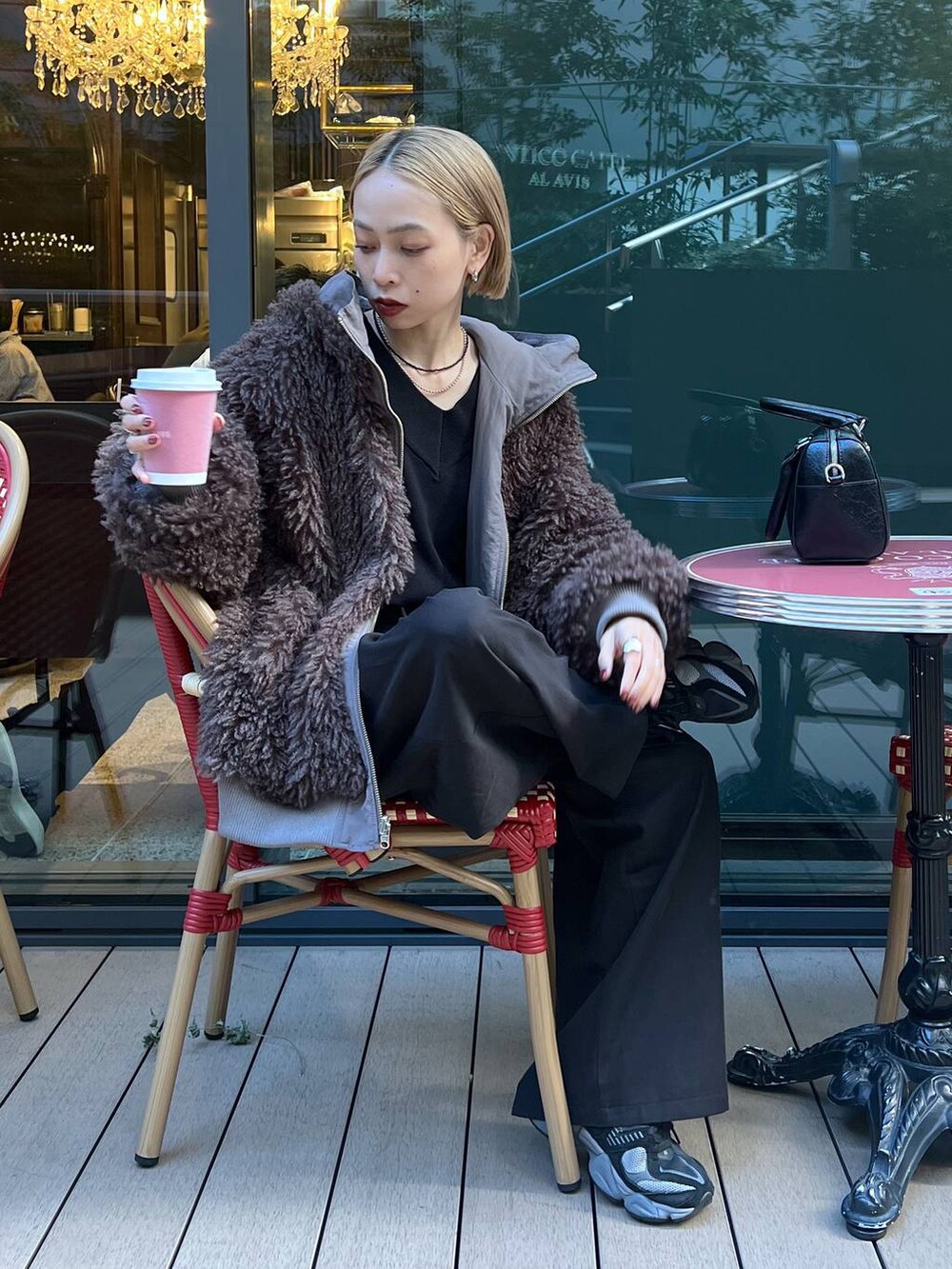 ブラウン系のブルゾン、ブラック系のニット/セーターを着用したレディースの秋コーディネートの6枚目の写真