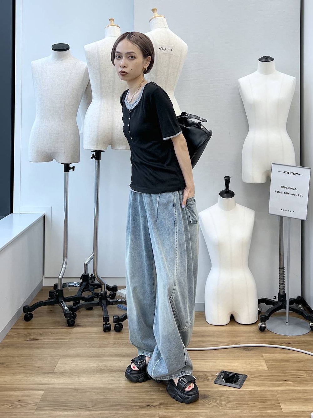ブルー系のデニムパンツ、ブラック系のサンダル、ブラック系のボストンバッグを着用したレディースの春コーディネートの6枚目の写真