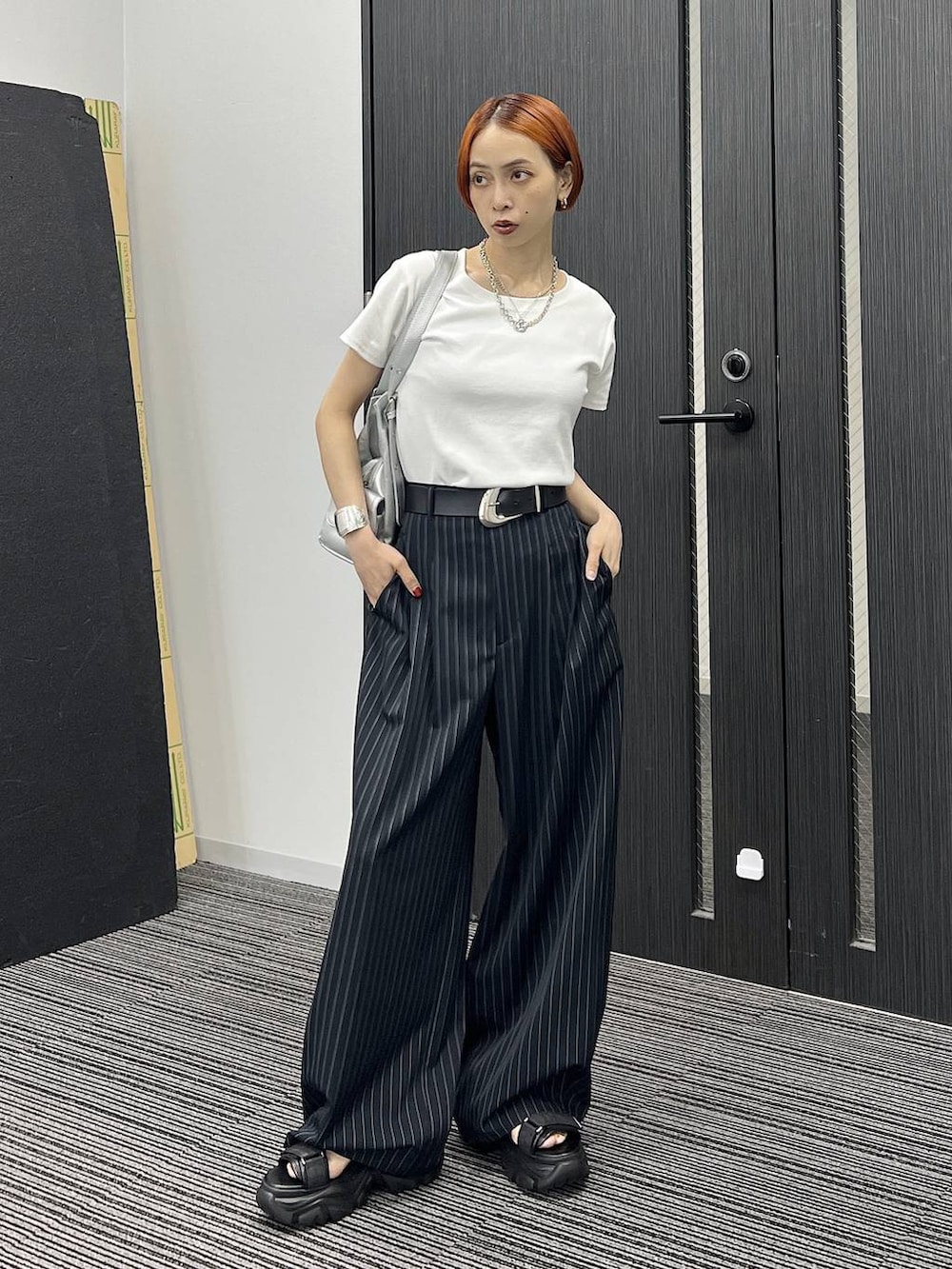 ブラック系のサンダル、シルバー系のハンドバッグ、ホワイト系のTシャツ/カットソーを着用したレディースの夏コーディネートの5枚目の写真