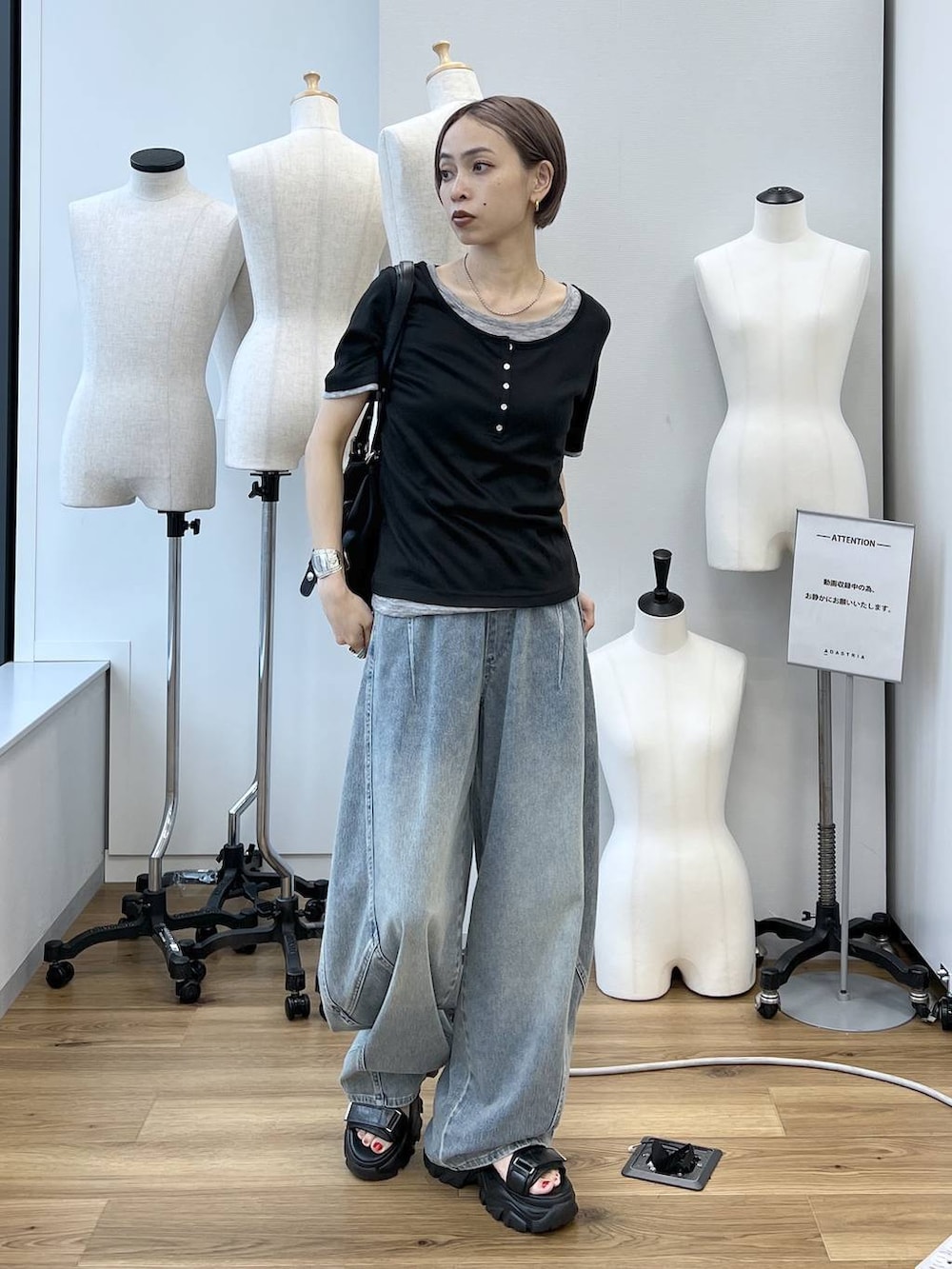 ブルー系のデニムパンツ、ブラック系のサンダル、ブラック系のボストンバッグを着用したレディースの春コーディネートの8枚目の写真