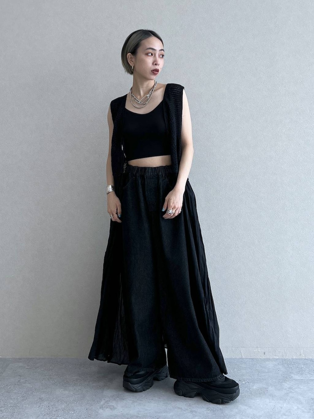 ブラック系のベスト、ブラック系のスニーカー、ブラック系のブラジャーを着用したレディースの夏コーディネートの3枚目の写真