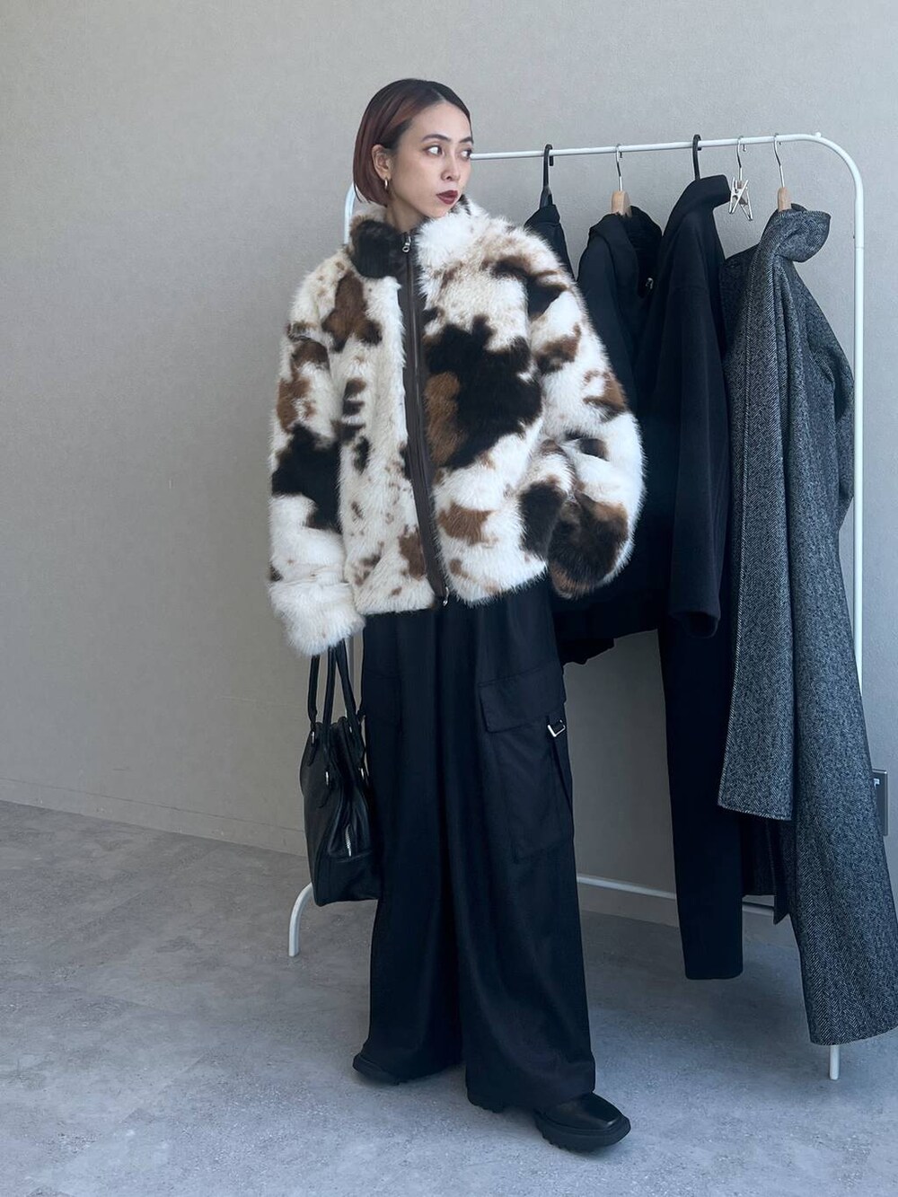 ブラック系のスラックス、ブラック系のボストンバッグを着用したレディースの秋コーディネートの2枚目の写真