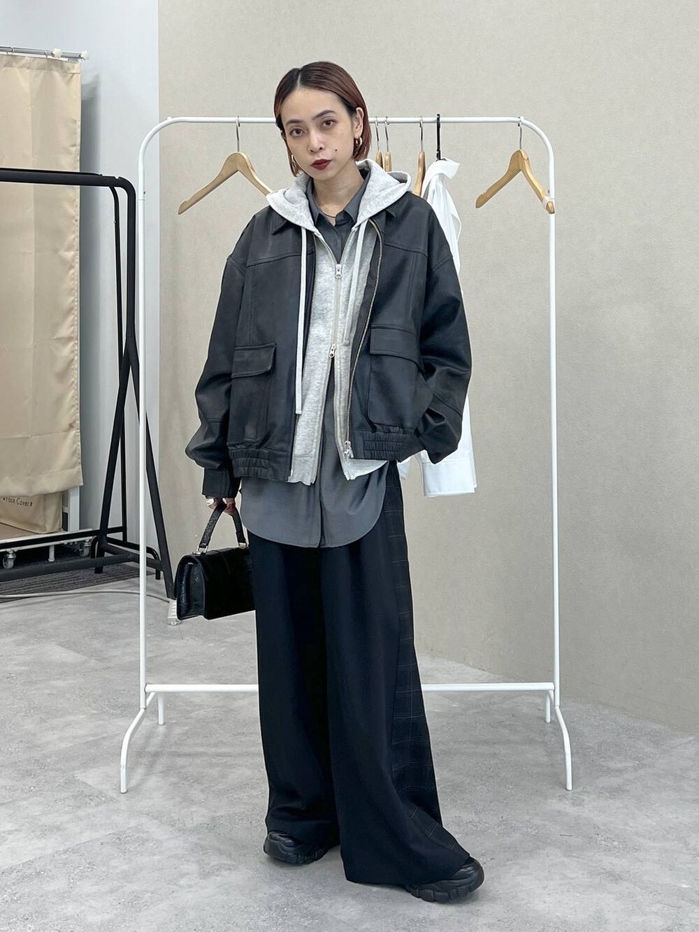 ブラック系のスニーカー、ブラック系のスラックス、ブラック系のハンドバッグを着用したレディースの秋コーディネートの2枚目の写真