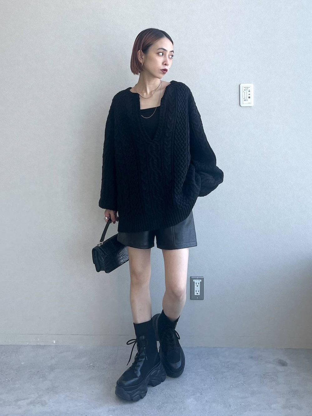 ブラック系のブーツ、ブラック系のハンドバッグ、ブラック系のニット/セーターを着用したレディースの秋コーディネートの2枚目の写真