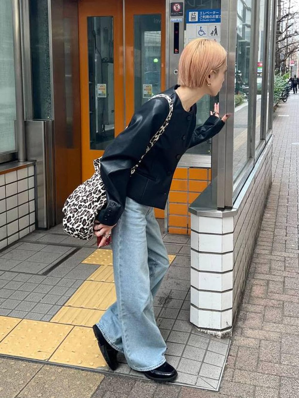 ブラック系のノーカラージャケットを着用したレディースの春コーディネートの2枚目の写真