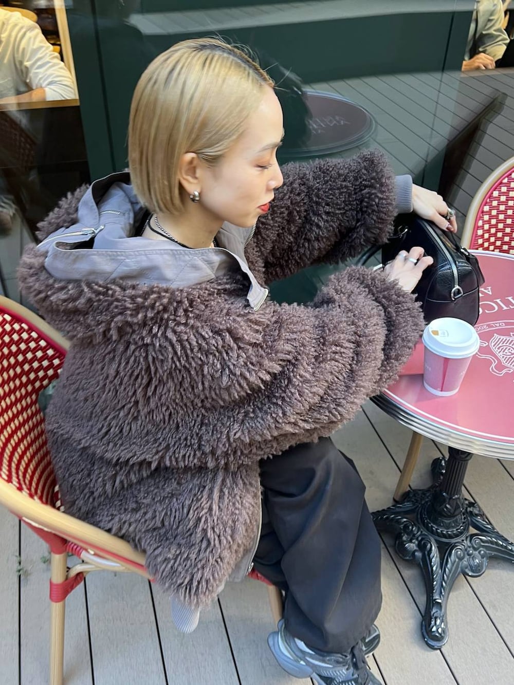 ブラウン系のブルゾン、ブラック系のニット/セーターを着用したレディースの秋コーディネートの7枚目の写真