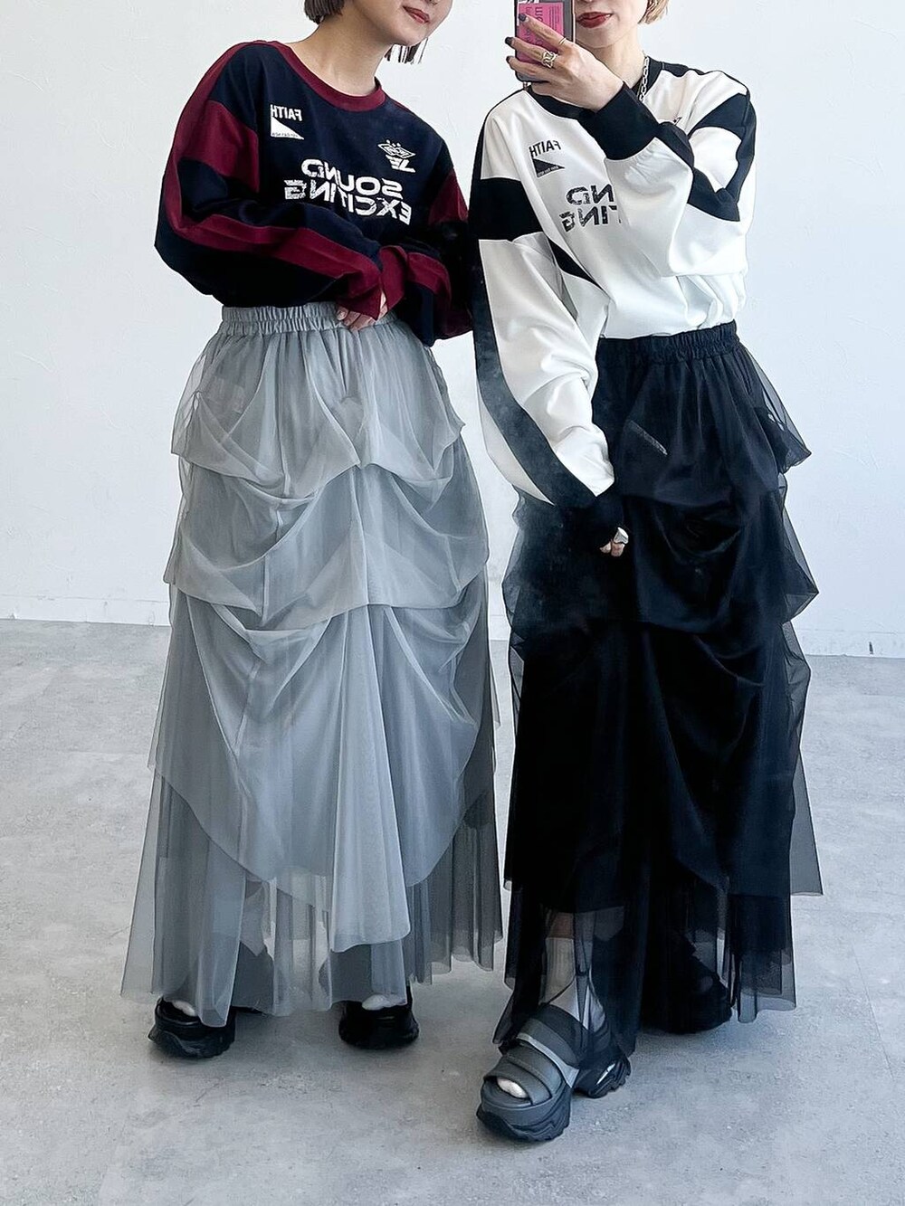 ブラック系のスカート、ホワイト系のTシャツ/カットソー、グレー系のサンダルを着用したレディースの春コーディネートの2枚目の写真