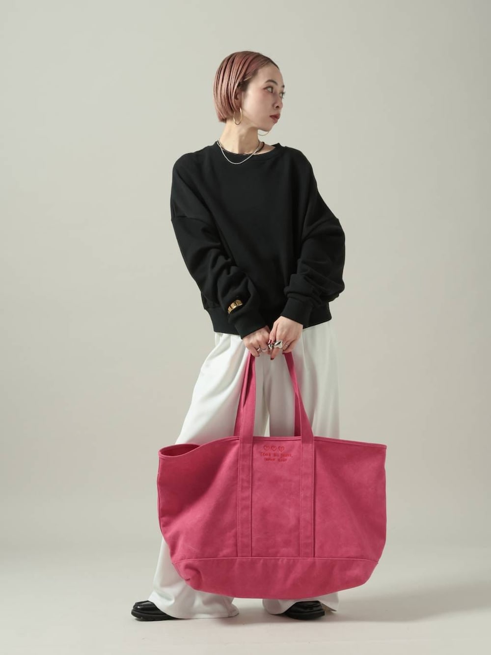 ブラック系のスウェット、ホワイト系のスラックスを着用したレディースの冬コーディネートの8枚目の写真