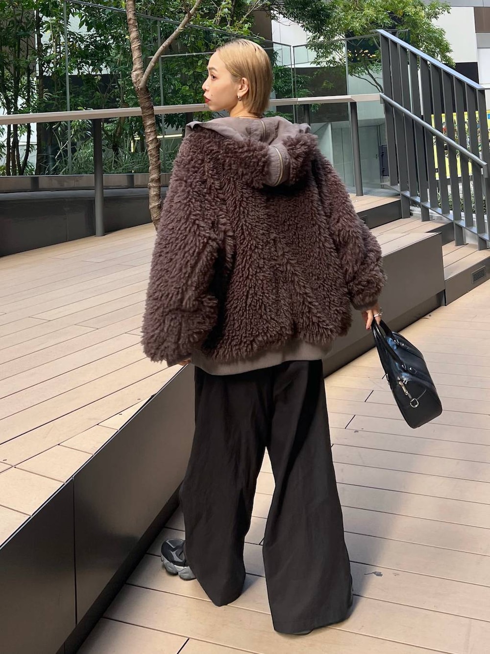 ブラウン系のブルゾン、ブラック系のニット/セーターを着用したレディースの秋コーディネートの3枚目の写真