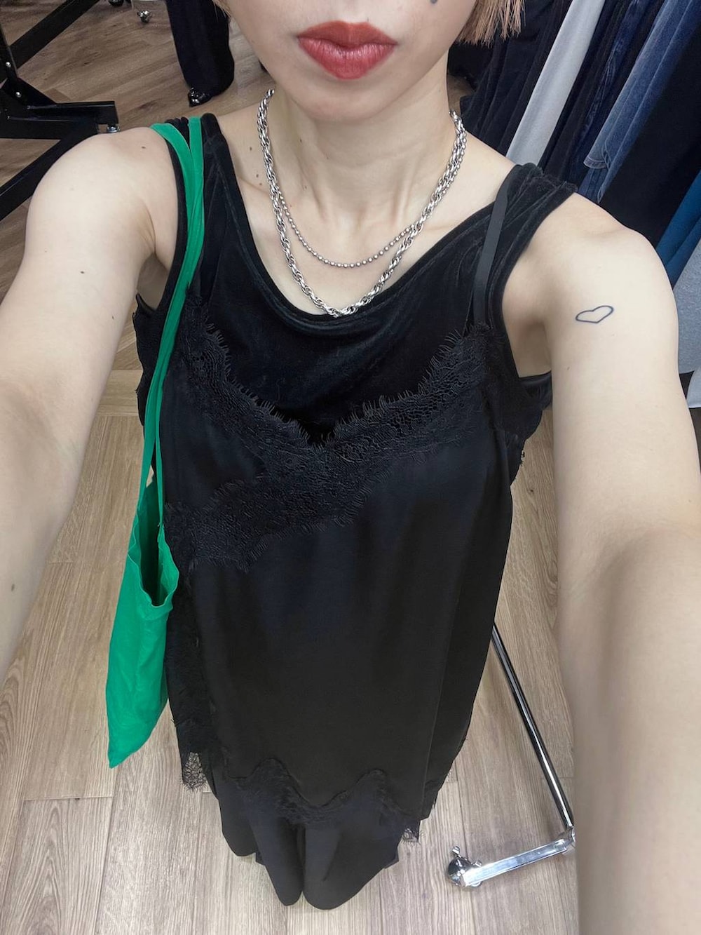 ブラック系のチュニック、ブラック系のスラックス、ブラック系のタンクトップを着用したレディースの夏コーディネートの9枚目の写真