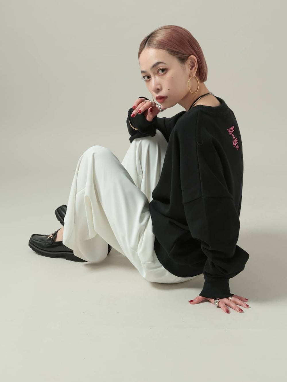 ブラック系のスウェット、ホワイト系のスラックスを着用したレディースの冬コーディネートの6枚目の写真