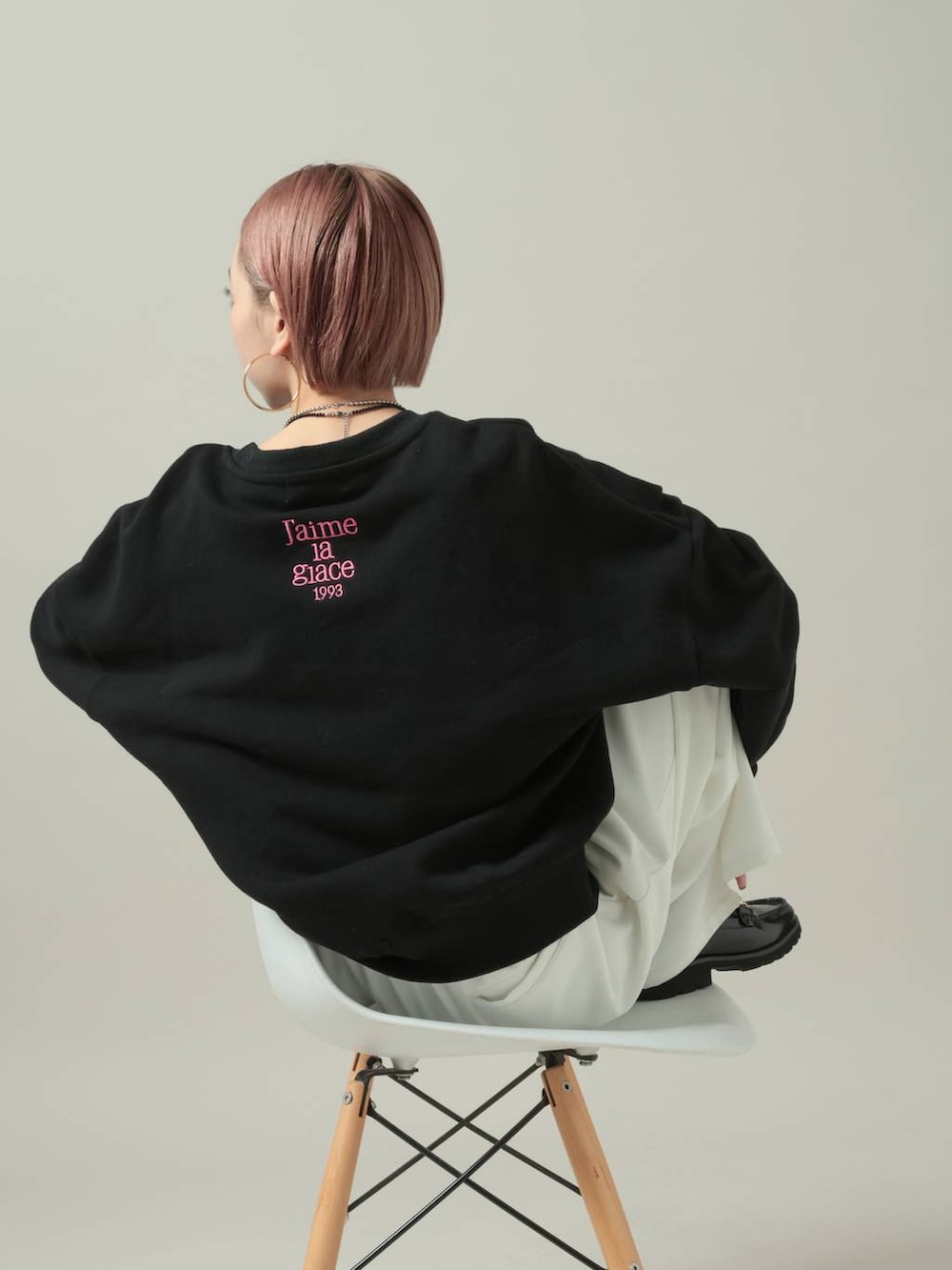 ブラック系のスウェット、ホワイト系のスラックスを着用したレディースの冬コーディネートの4枚目の写真