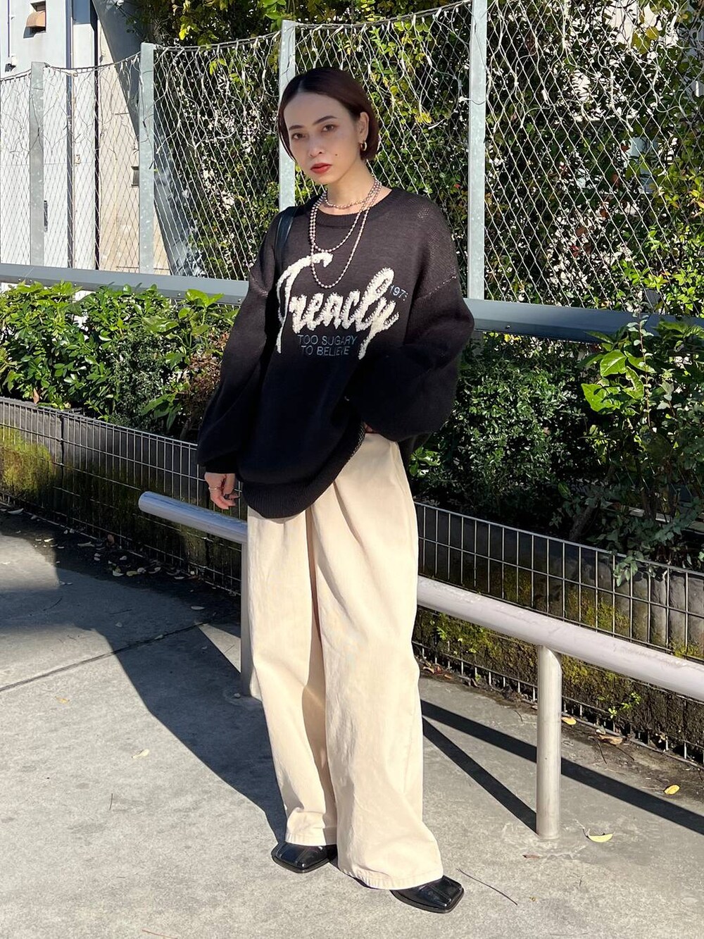 ブラック系のショルダーバッグ、ブラック系のブーツ、ブラック系のニット/セーターを着用したレディースの冬コーディネートの5枚目の写真