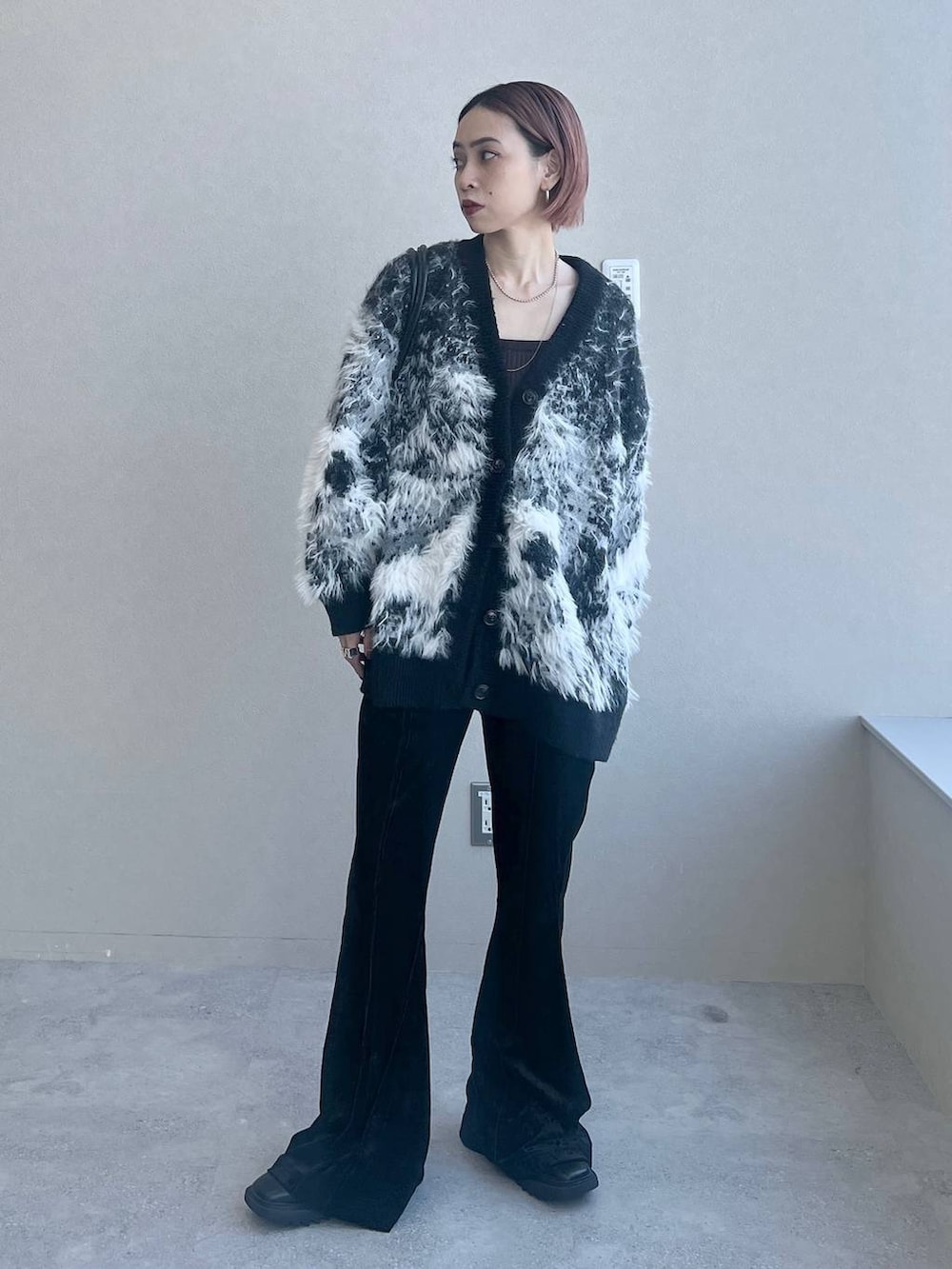 ブラック系のその他パンツ、ブラック系のボストンバッグ、ブラック系のカーディガン/ボレロを着用したレディースの秋コーディネートの3枚目の写真