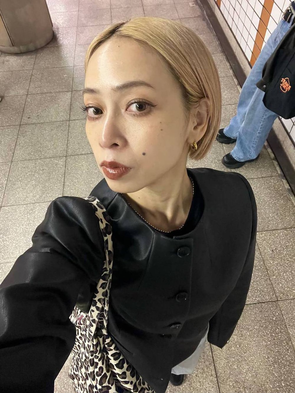 ブラック系のノーカラージャケットを着用したレディースの春コーディネートの6枚目の写真