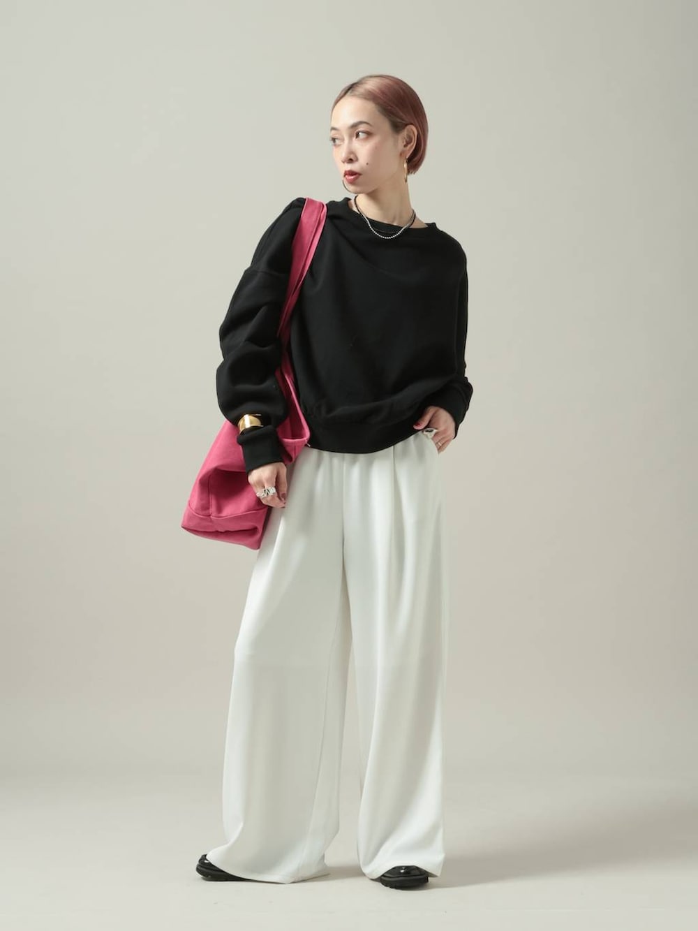 ブラック系のスウェット、ホワイト系のスラックスを着用したレディースの冬コーディネートの7枚目の写真