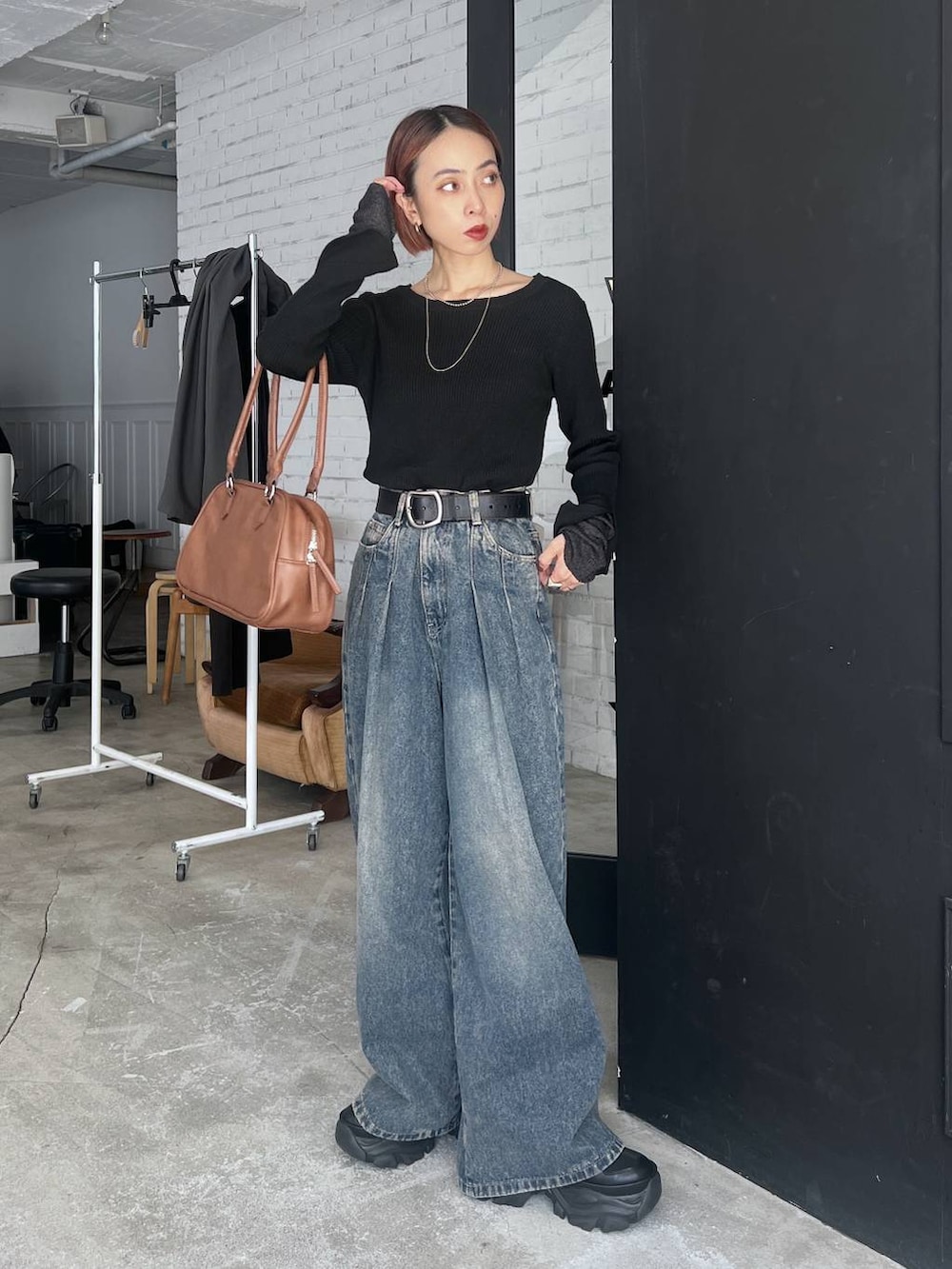 ブラック系のスニーカー、ブルー系のデニムパンツ、イエロー系のボストンバッグを着用したレディースの秋コーディネートの6枚目の写真