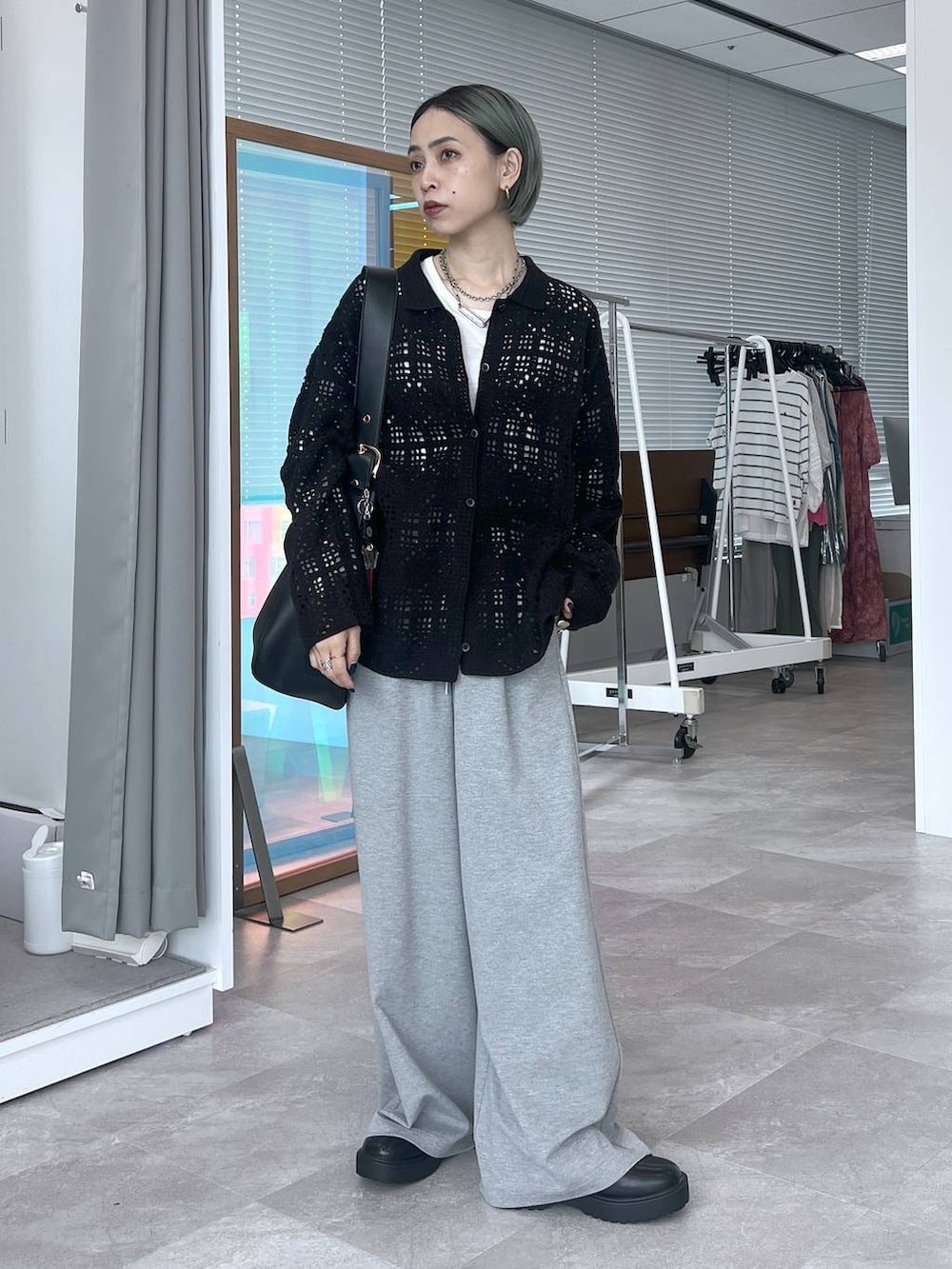 ブラック系のその他アウター、ブラック系のショルダーバッグ、ホワイト系のTシャツ/カットソーを着用したレディースの秋コーディネートの2枚目の写真