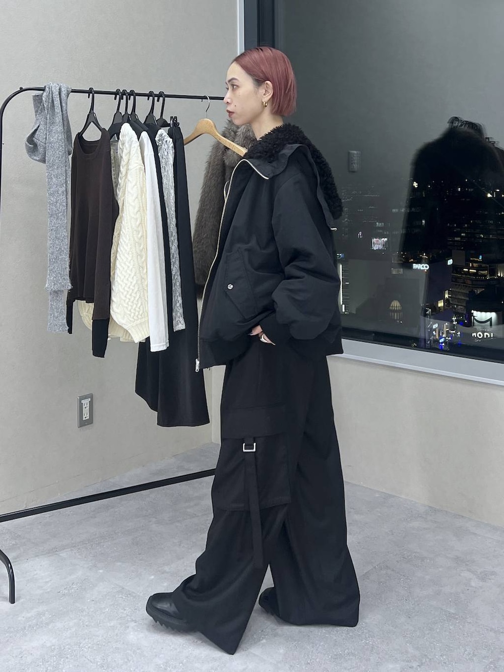 ブラック系のブルゾン、ブラック系のスラックス、レッド系のニット/セーターを着用したレディースの冬コーディネートの3枚目の写真