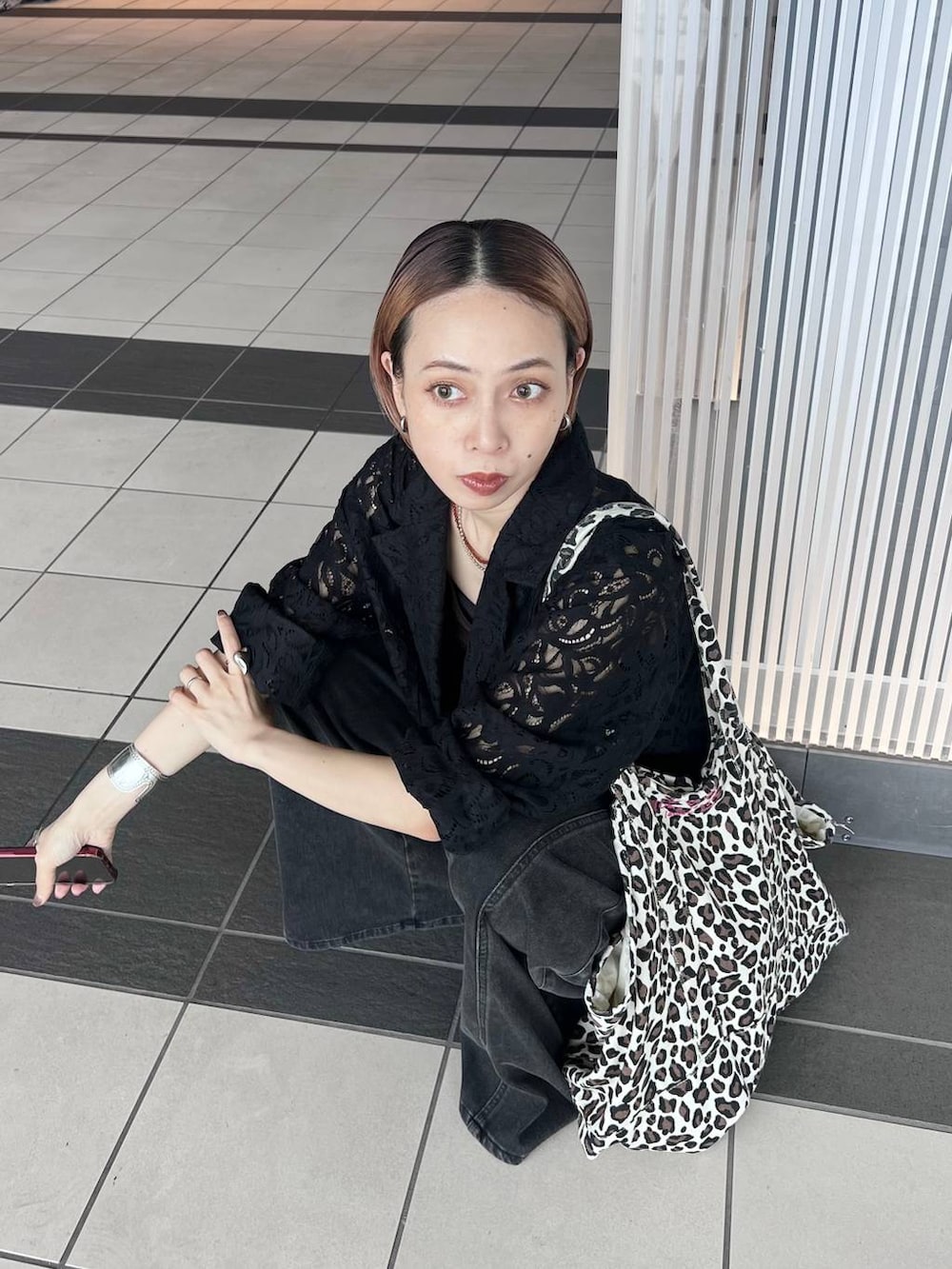 ブラック系のデニムパンツ、ブラック系のテーラードジャケット、ブラウン系のタンクトップを着用したレディースの夏コーディネートの2枚目の写真