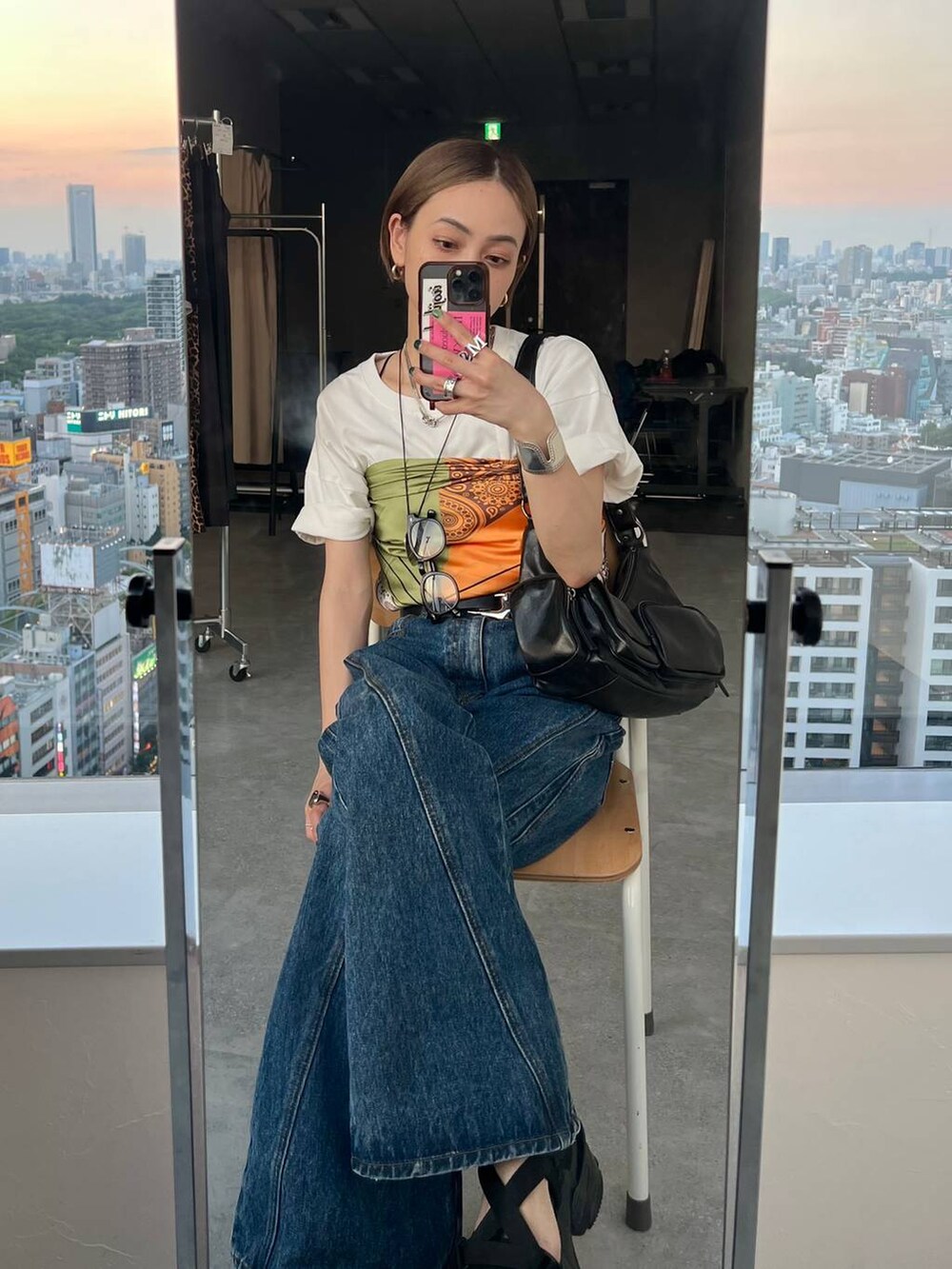 ブラック系のショルダーバッグ、ブラック系のサンダル、ブルー系のデニムパンツを着用したレディースの夏コーディネートの3枚目の写真