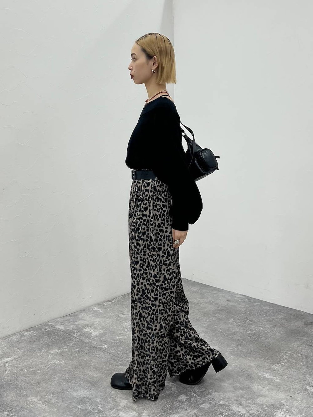 ブラック系のその他シューズ、ブラック系のニット/セーター、ブラック系のショルダーバッグを着用したレディースの秋コーディネートの4枚目の写真