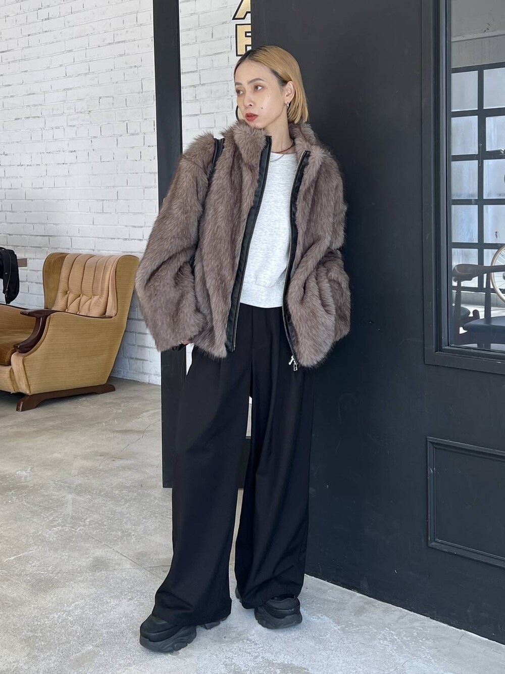 ブラック系のショルダーバッグ、ブラウン系のブルゾンを着用したレディースの秋コーディネートの2枚目の写真