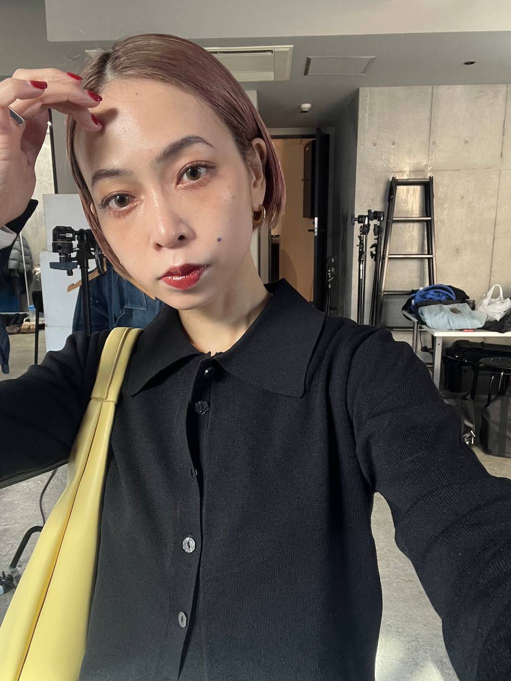 ブラック系のサンダル、イエロー系のトートバッグ、ブルー系のデニムパンツを着用したレディースの冬コーディネートの4枚目の写真