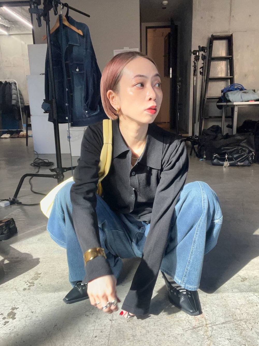 ブラック系のサンダル、イエロー系のトートバッグ、ブルー系のデニムパンツを着用したレディースの冬コーディネートの3枚目の写真