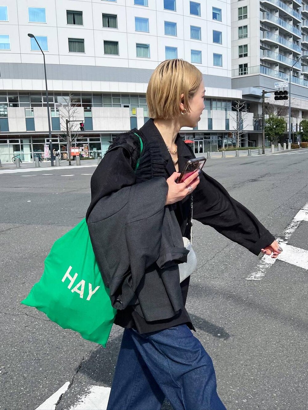 シルバー系のサンダル、ブルー系のデニムパンツを着用したレディースの春コーディネートの2枚目の写真