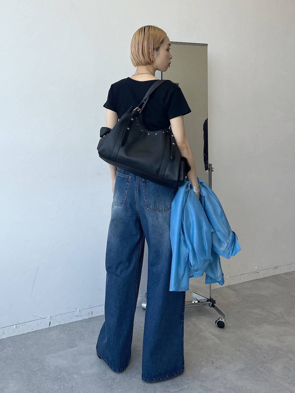 ブルー系のシャツ/ブラウス、ブラック系のTシャツ/カットソー、ブルー系のデニムパンツを着用したレディースの春コーディネートの3枚目の写真