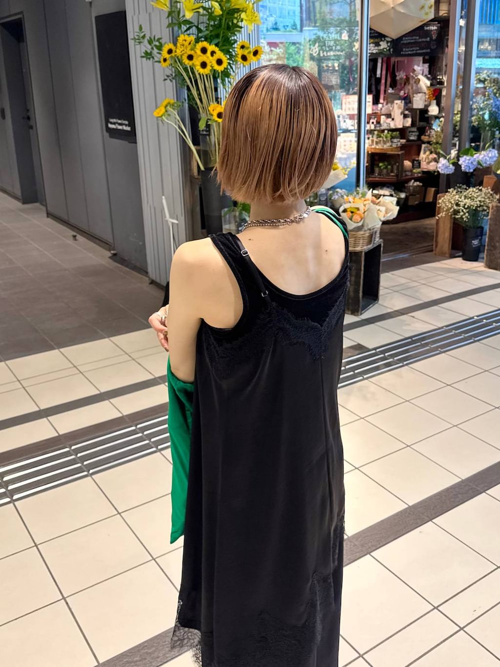 ブラック系のチュニック、ブラック系のスラックス、ブラック系のタンクトップを着用したレディースの夏コーディネートの8枚目の写真