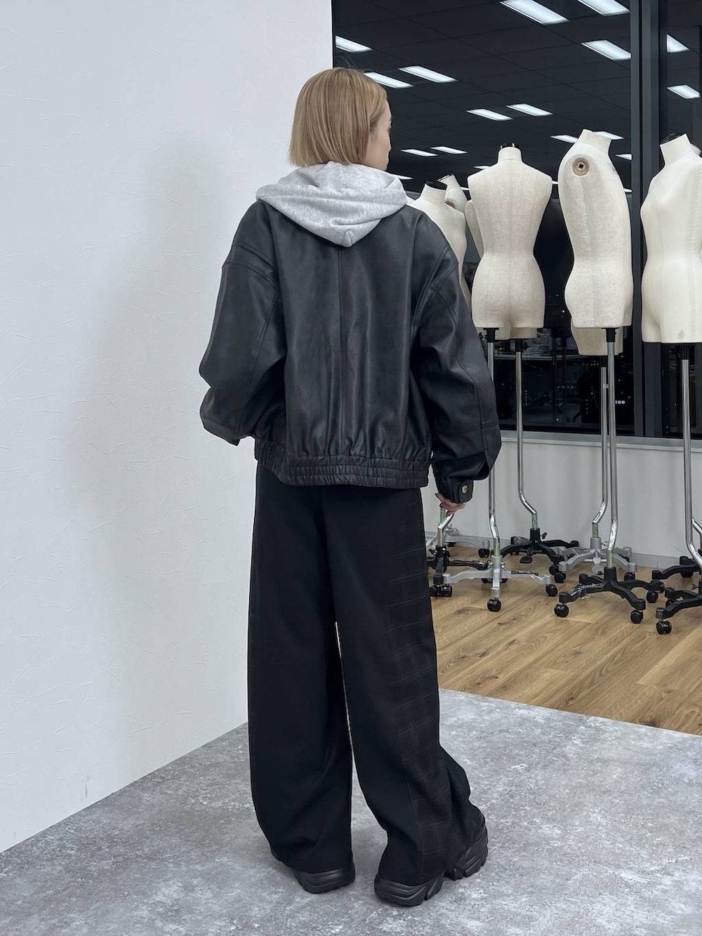 ブラック系のブーツ、ブラック系のスラックス、ブラック系のブルゾンを着用したレディースの秋コーディネートの5枚目の写真