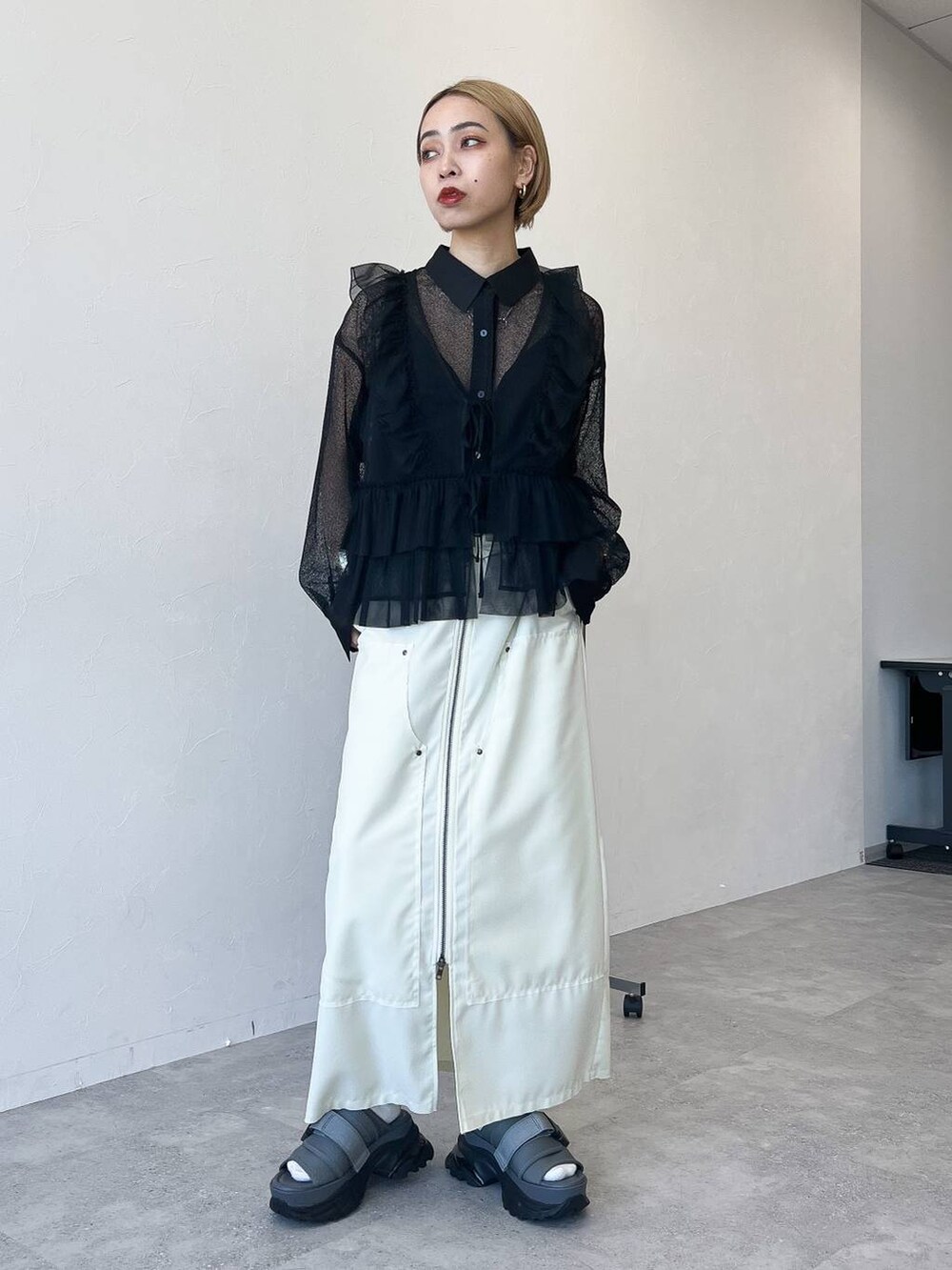 ブラック系のベスト、ブラック系のシャツ/ブラウス、ホワイト系のスカートを着用したレディースの春コーディネートの2枚目の写真