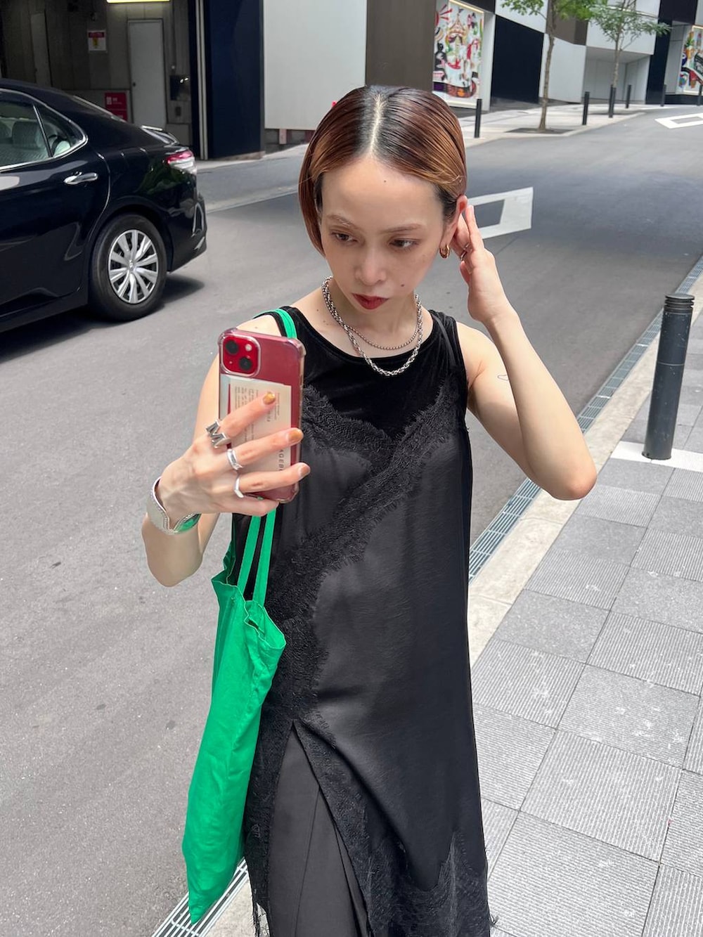 ブラック系のチュニック、ブラック系のスラックス、ブラック系のタンクトップを着用したレディースの夏コーディネートの3枚目の写真